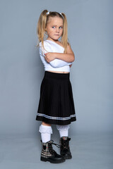 young girl gives a playful, defiant look with her arms crossed, embodying a spirited and confident...