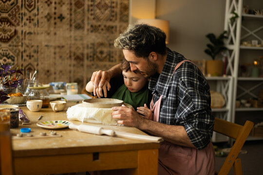 Father and son are sculpting with clay. Father and son are spending time together. Clay modeling workshop.

