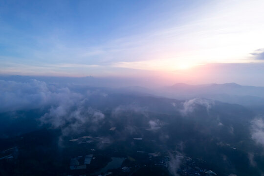 Aerial view Serene mountains at dawn. Pink blue sky over rolling peaks, mist in valleys
