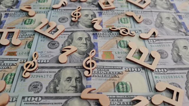 Money with music notes on top showing connection between finance and art in a creative display