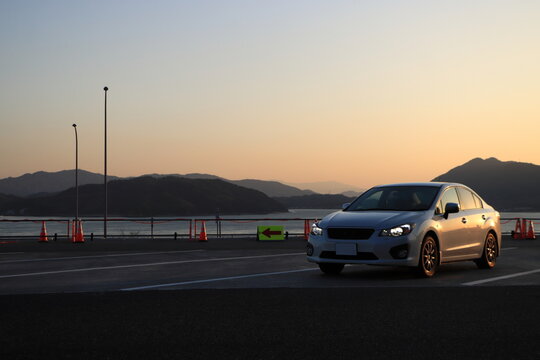 車と夕焼けの海の風景