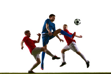 Fototapeta premium Soccer player in blue kicking ball between two red defenders in studio action. Concept of fast attack, defensive pressure, sports advertising, match promo and game tactics.