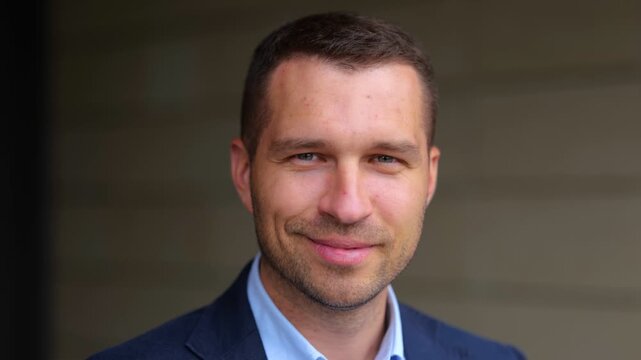 Close up of happy handsome man looking at camera and smiling in good mood. Caucasian cheerful professional male with smile on face. Business successful people. Real time concept.