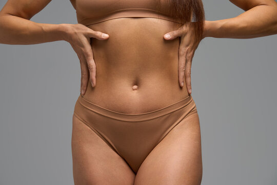 Close-up of woman with hands on waist showing muscle soreness and body awareness