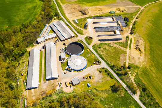 Biogas plant and farm in fields. Renewable energy from biomass. Aerial view to Czech industry. Sustainable development in European Union.	

