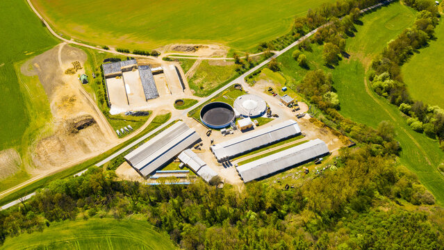 Biogas plant and farm in fields. Renewable energy from biomass. Aerial view to Czech industry. Sustainable development in European Union.	
