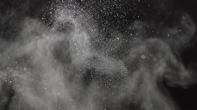 White powder dust particles exploding and floating on dark background for dramatic slow motion effect
