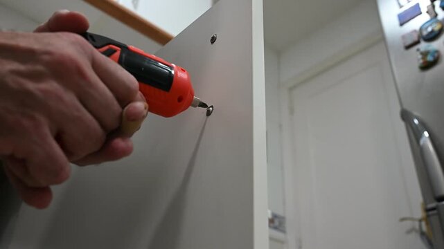 Using screwdriver to assemble furniture details
