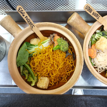 Ramen egg noodles in clay pot with vegetables 