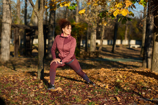Woman doing lunges in autumn park