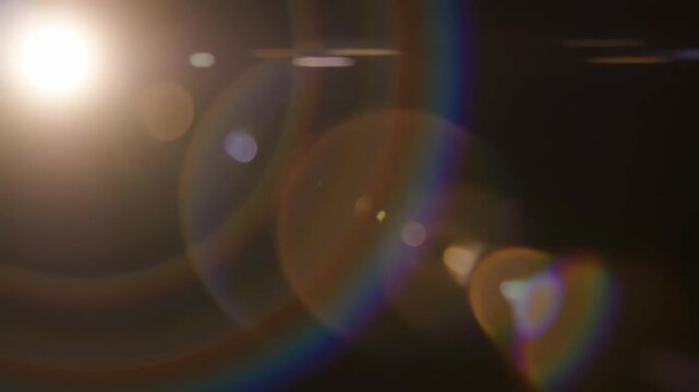 A mesmerizing transition from darkness to light, showcasing the intricate play of reflections and lens flares that illuminate the scene with vibrant colors and textures.