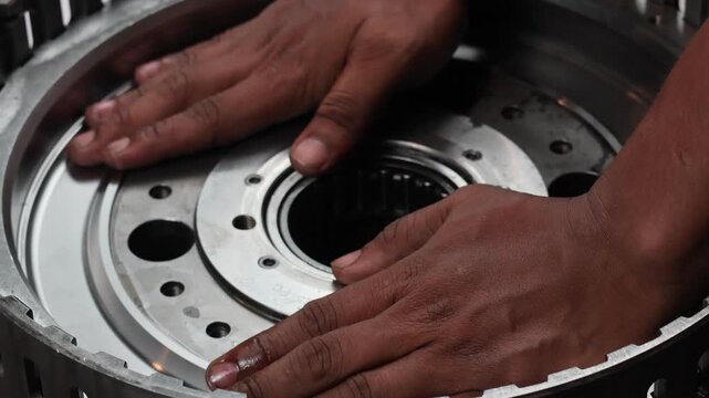 A close-up, static shot of a mechanic's hands carefully aligning and installing a piston into a heavy-duty machinery part.