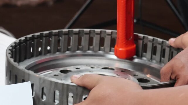 A close-up, static shot of a mechanic using a rubber dead blow hammer to carefully seat a piston into its housing. The footage demonstrates professional manual assembly.