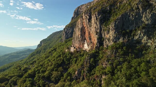 Ostrog Monastery In the cliff  Montenegro at sunset, drone establishing shot. Famous destination of Balkans. 