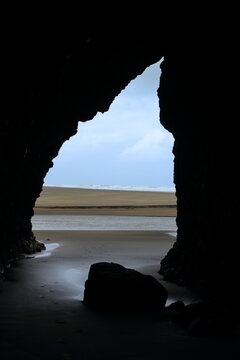 View Through Sea Cave Opening to Sandy Beach at Bethells Beach New Zealand