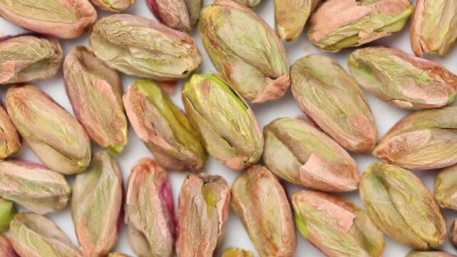 Pile of roasted shelled pistachio kernels rotating slowly. Top view shot