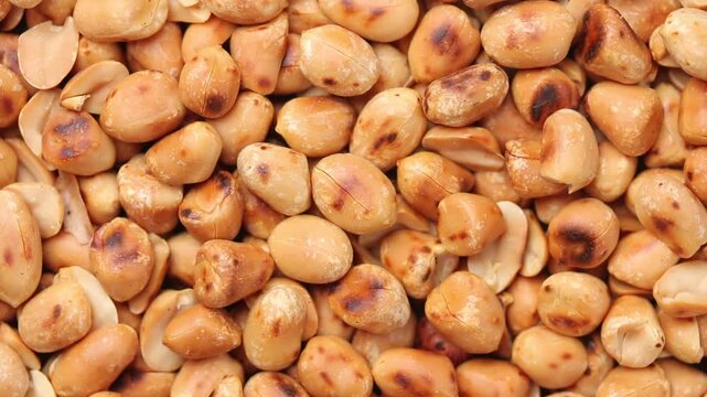 Top view of a slowly rotating pile of roasted hulled peanuts.  close-up view 
