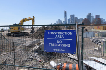 Naklejka premium blue EllisDon construction area sign at Port Lands, with skyline of downtown Toronto
