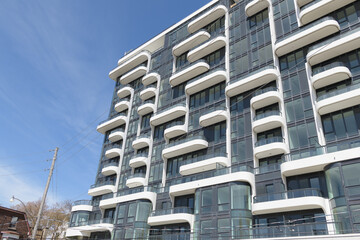 Naklejka premium the ANX at 328 Dupont Street, designed by Teeple Architects for Freed Developments in 2023, is a 13-storey Expressionist Modernist mixed-use condominium characterized by its undulating white aluminum 