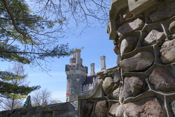 Naklejka premium distant view of East Tower at Casa Loma with detail of stone fence, spring morning, Toronto
