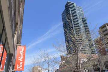 Naklejka premium banner sign outside Tim Hortons, a coffee shop chain, located here at 18 Yorkville Av (view is north on Yonge St & building: The Milan Condominiums), Toronto