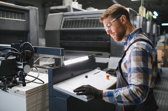 Print factory operator working with offset machine controls