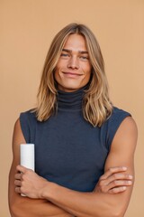 Fototapeta premium Young male model crossing arms while holding container in studio