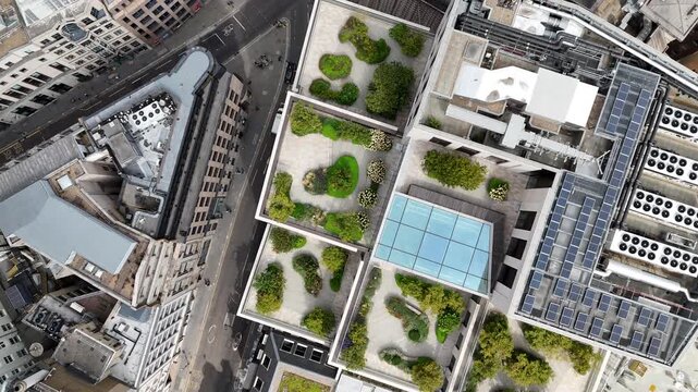 Cinematic top down aerial drone footage of modern rooftops, urban streets and geometric architecture in central London. Contemporary city design and urban patterns captured from above.