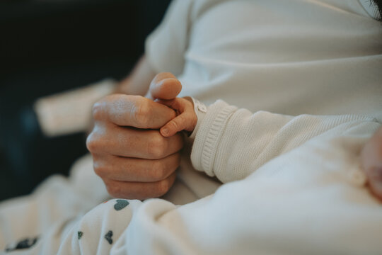 Gros plan sur la main d'un nouveau-n&eacute; serrant le doigt d'un adulte 