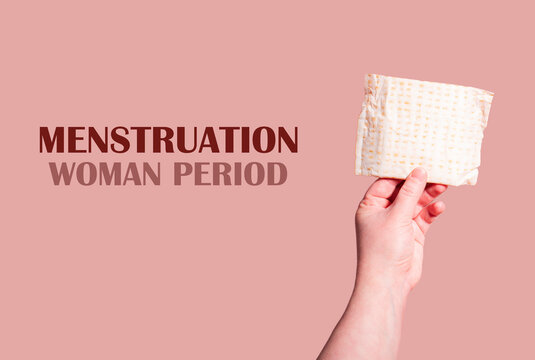 Classic menstrual pads in woman hand. Menstrual cycle and suffering from menstrual pain. Female period and intimate hygiene