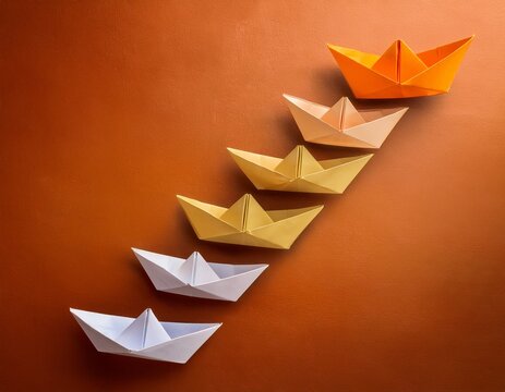 orange step with origami boats ascending one gold on gradient background representing journey growth ambition and leadership mockup free space