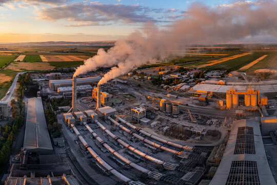 drone view of Industrial cement plant with smokestacks and agricultural fields at sunset, spherical projection