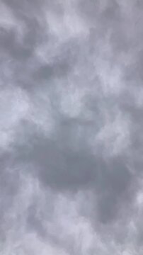 Dramatic dark gray storm clouds in a blue sky move in a nature timelapse showing a summer rain thunderstorm and windy weather cloudscape