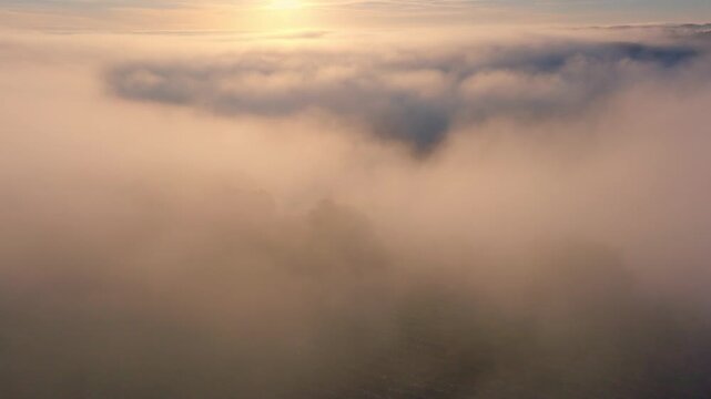 Golden sunlight filtering through dense clouds and fog