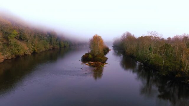 River flowing through a misty autumn forest