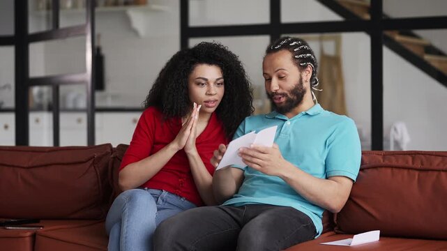 Young couple reading a letter, celebrating citizenship application approval