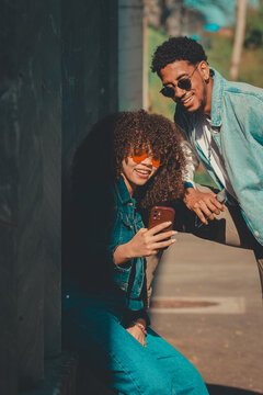 young latin couple with mobile phone on the street