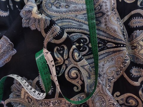 Motif cachemire sur tissu sombre avec m&egrave;tre ruban &ndash; d&eacute;tail textile et couture &eacute;l&eacute;gante