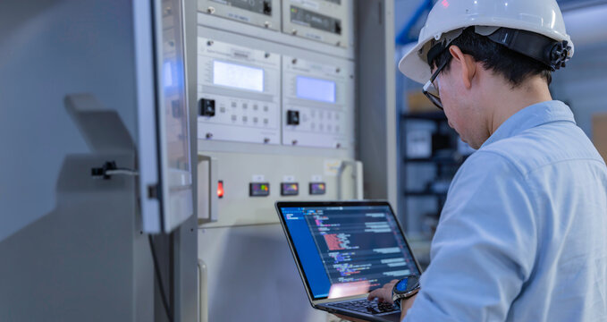 Electrical engineer male checking voltage at the Power Distribution Cabinet in the control room,preventive maintenance Yearly,inspecting power system and control panel in industrial factory