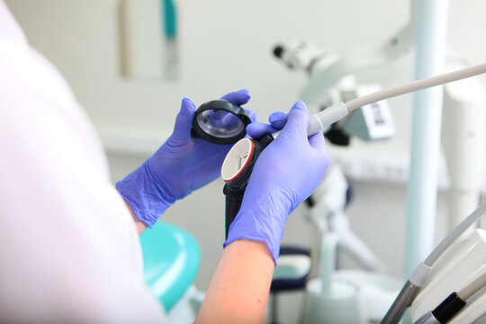 Device for sandblasting teeth in the hands of a doctor. An effective method of oral hygiene. Sandblasting teeth cleaning. The aesthetics of a smile. Prevention of dental diseases.