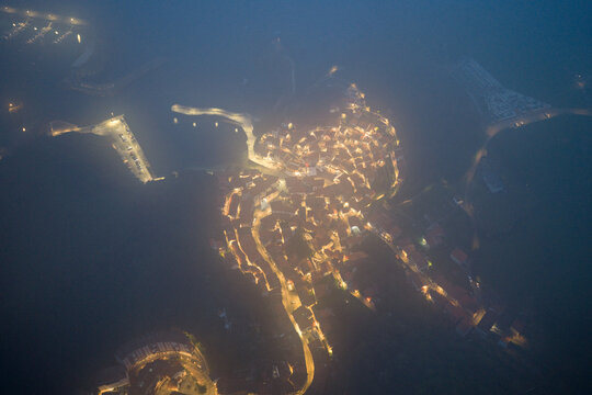Aerial view of the historic town glowing through thick night mist and fog Cudillero, Asturias, Spain.