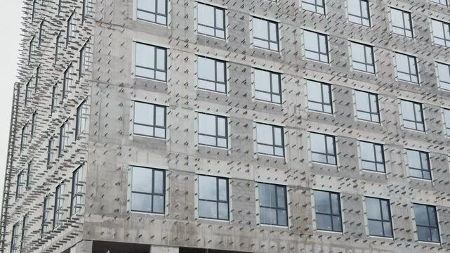 the facade of a new multi-storey residential complex, the house is being prepared for the installation of a ventilated facade, the installation of fasteners