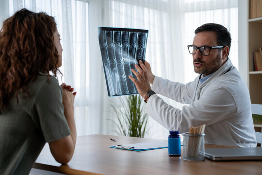 Doctor explaining lumbar spine MRI results to patient in consultation 