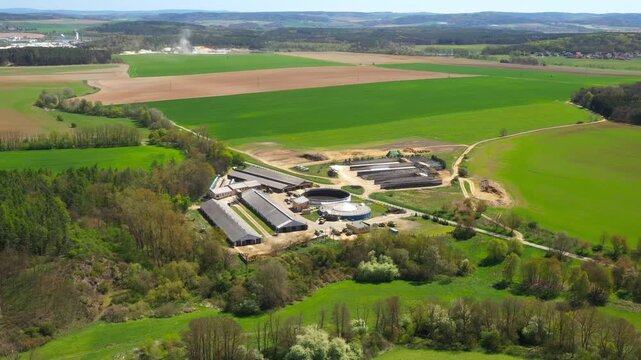 Biogas plant and farm in fields. Renewable energy from biomass. Aerial view to Czech industry. Sustainable development in European Union.
