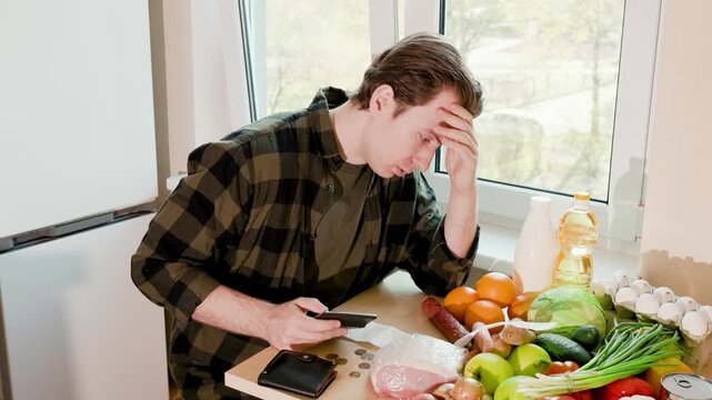 Stressed man counts coins and checks an empty wallet amid high food prices, illustrating the economic crisis, inflation, and price increases in this 4K video. High quality footage