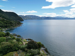 Obraz premium aerial view of lake atitlan with ferry boats in the water guatemala volcano vulcanic mountains volcanoes crater beautiful travel tourism destination latin america ferry port dock shore serene water