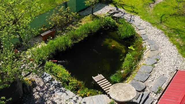 Root wastewater treatment plant as a garden pond. Relaxation zone with fish farming in an organic garden from above. Sustainable development in gardening and aquaculture.