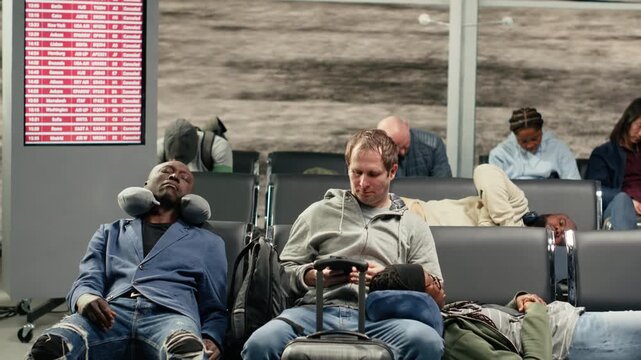 Fatigued people in airport lounge lying down on metallic benches during prolonged layover. Weary passengers resting on seats, dozing while waiting for plane, concept of flight delay, camera A