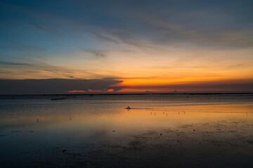 Obraz premium Fiery orange sunset over calm ocean horizon, peaceful seascape