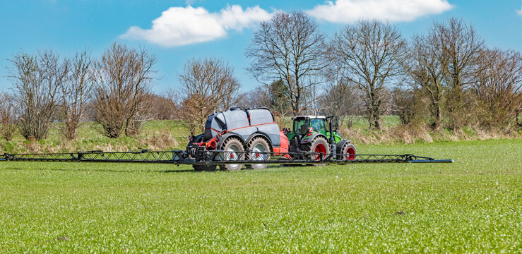 Tractor with a tank trailer and spray boom in the field &ndash; 9242